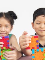Asian children are playing puzzle plastic block creative game to practice their physical and mental skill